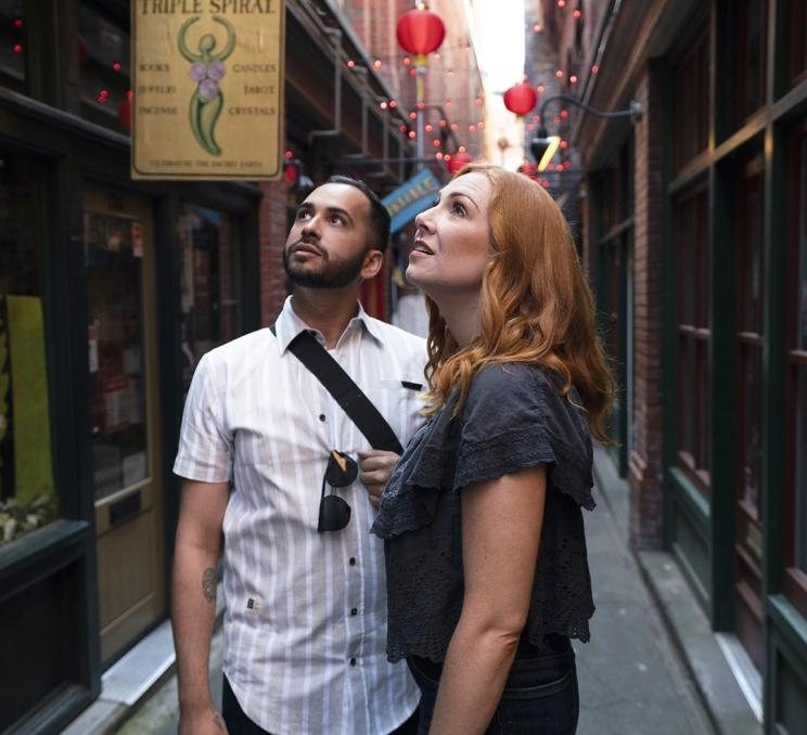 A couple explores Fan Tan Alley, Canada's narrowest street, in Victoria, BC