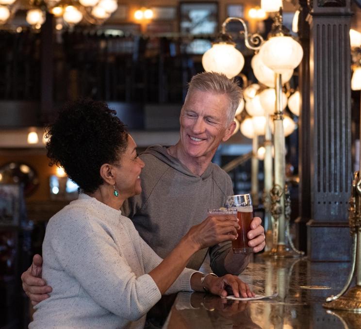 A couple enjoys a beer and a cocktail at the Bard & Banker in Victoria, BC