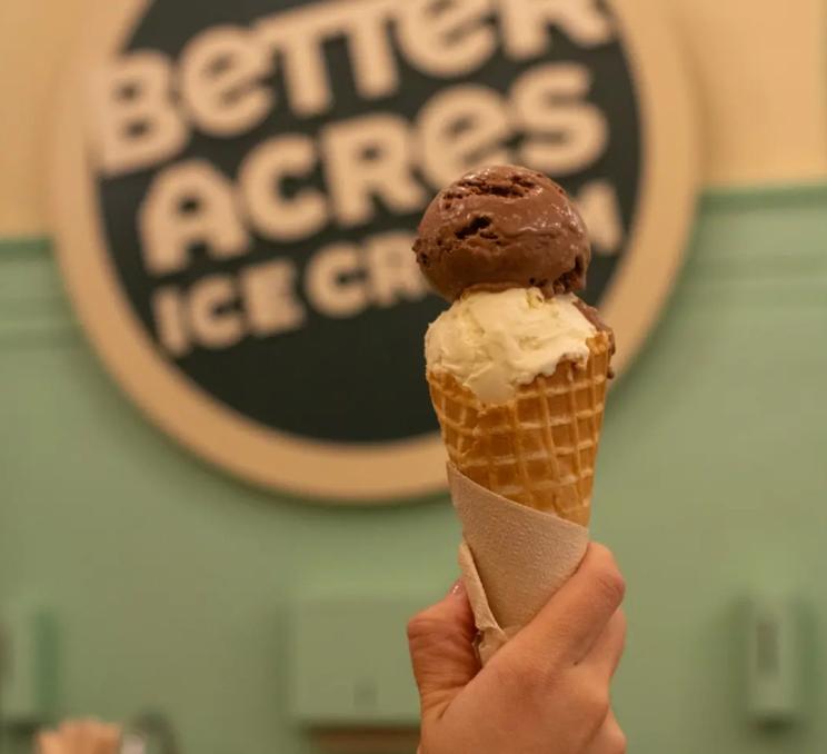 A person holds up a chocolate and vanilla ice cream cone at Better Acres Ice Cream in Victoria, BC