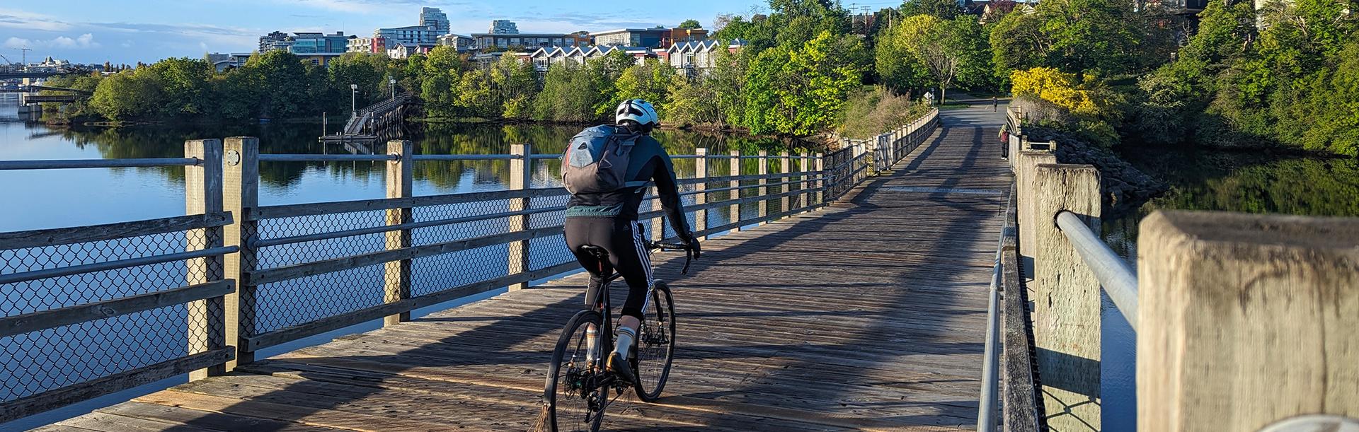 A cyclist rides along the Selkirk Trestle at Sunrise in Victoria, BC