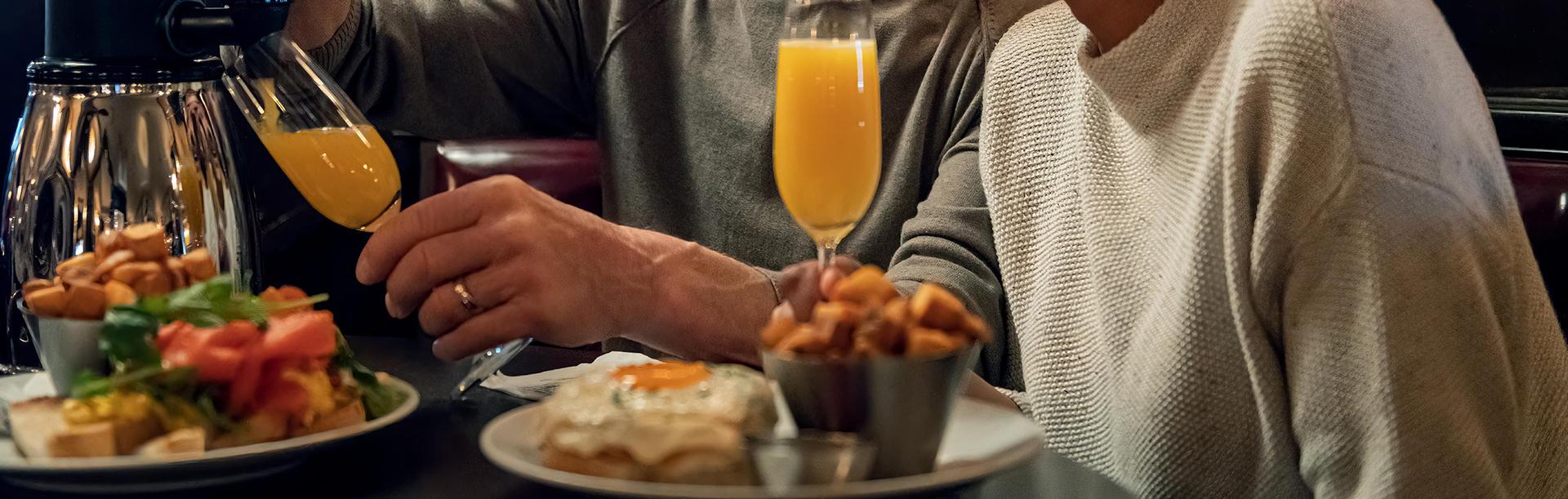 A couple enjoys brunch and mimosas at the Bard & Banker in Victoria, BC