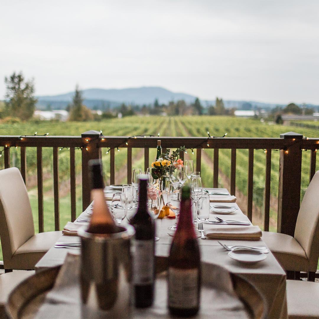 A dining table on a patio is set-up for a wedding overlooking the vineyard of Church & State Winery in Victoria, BC
