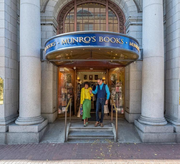 A couple exits Munro's Books after shopping along Government Street in Victoria, BC