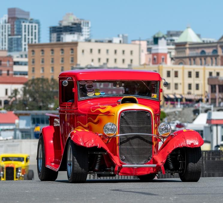 A red Deuce Coup drives through the streets of Victoria, BC