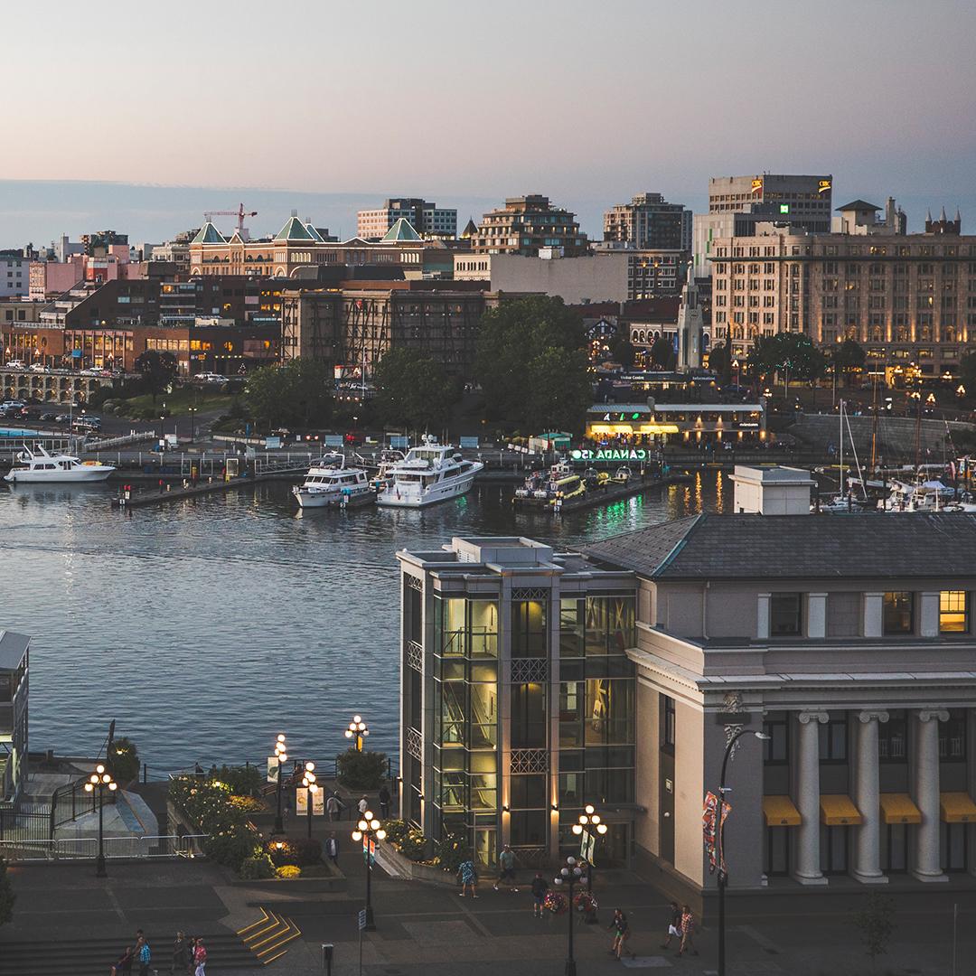 An aerial view of the Steamship Terminal Building and the Inner Harbour at sunset in Victoria, BC