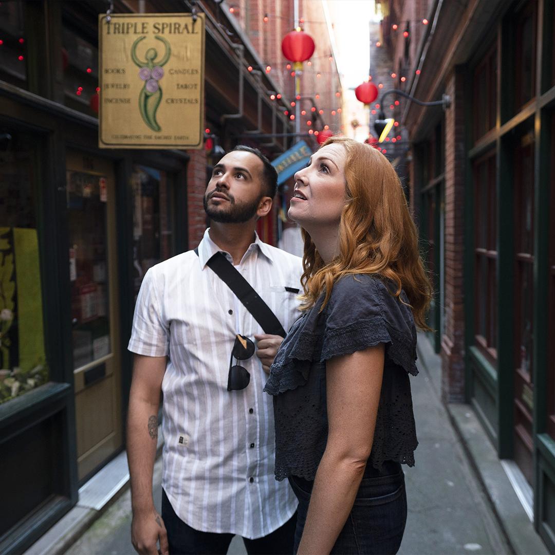 A couple examines the architecture inside Fan Tan Alley, Canada's narrowest street, in the historic Chinatown of Victoria, BC