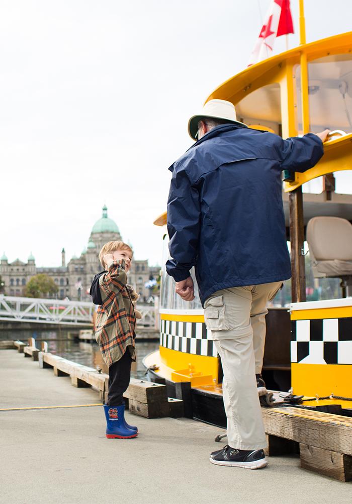 A young boy talks with a Harbour Ferry Captain on a dock in the Inner Harbour of Victoria, BC