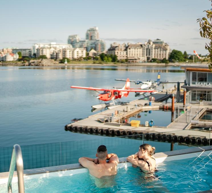 A couple soaks in a hot tub overlooking Victoria, BC's Inner Harbour at HAVN Saunas