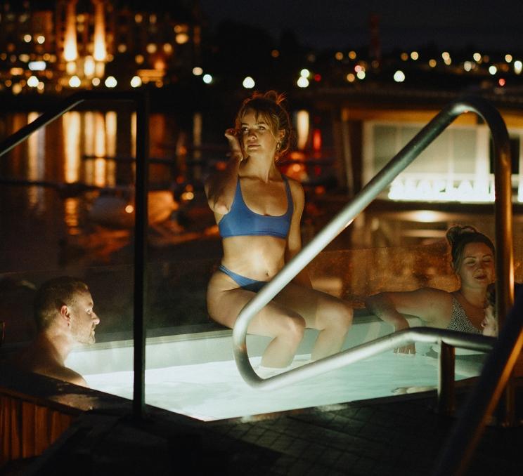 A woman sits on the edge of a soaker tub at HAVN Saunas in Victoria, BC