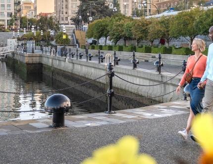 A couple walks along the Inner Harbour Lower Causeway in Victoria, BC
