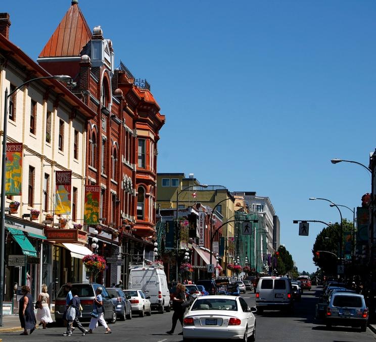Pedestrians cross the street during some light traffic along Lower Johnson Street in Victoria, BC