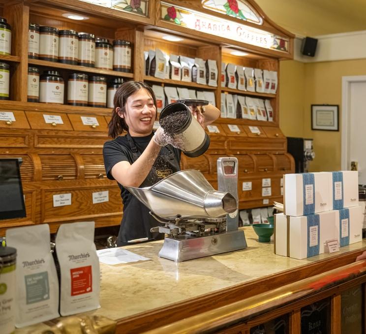 A woman pours loose leaf tea for packaging at Murchie's Tea & Coffee in Victoria, BC