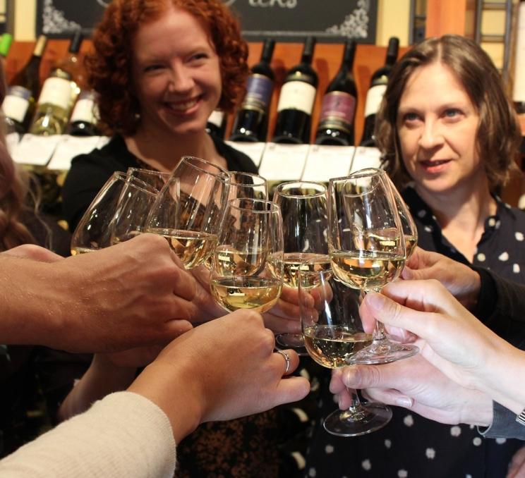A group of women enjoy a glass of wine during an Off the Eaten Track Food Tour in Victoria, BC
