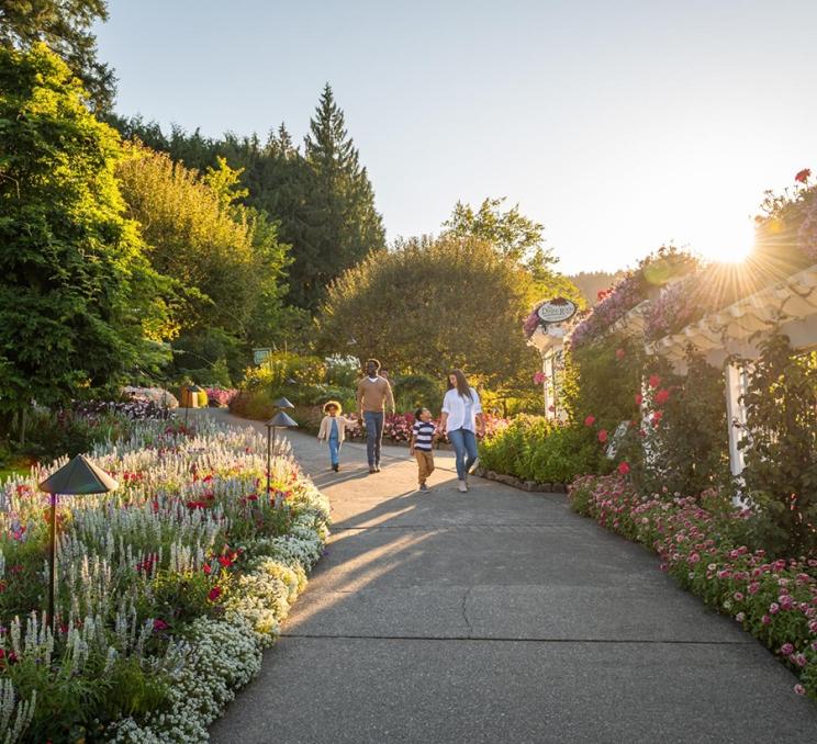 A young family walks along a pathway at The Butchart Gardens in Victoria, BC