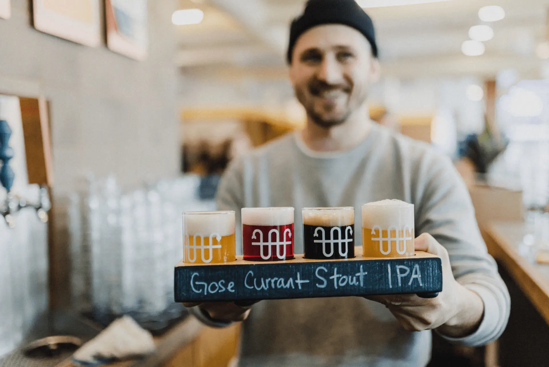 A person holding a flight of beers at Buoy Brewing in Victoria, BC